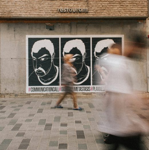 Dynamic street art scene with blurred pedestrians passing by a restaurant wall.